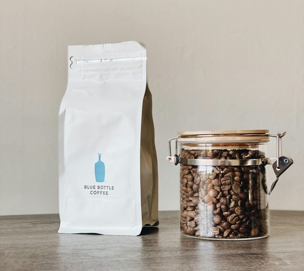 Pak koffiebonen en een kop koffie op een keukentafel