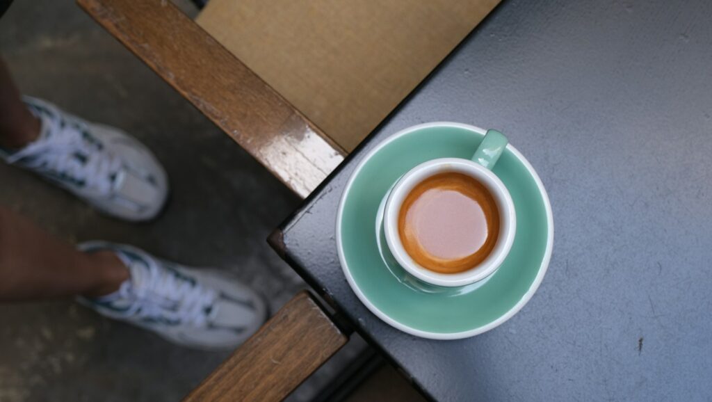 Dubbele espresso op een tafel naast een paar hardloopschoenen
