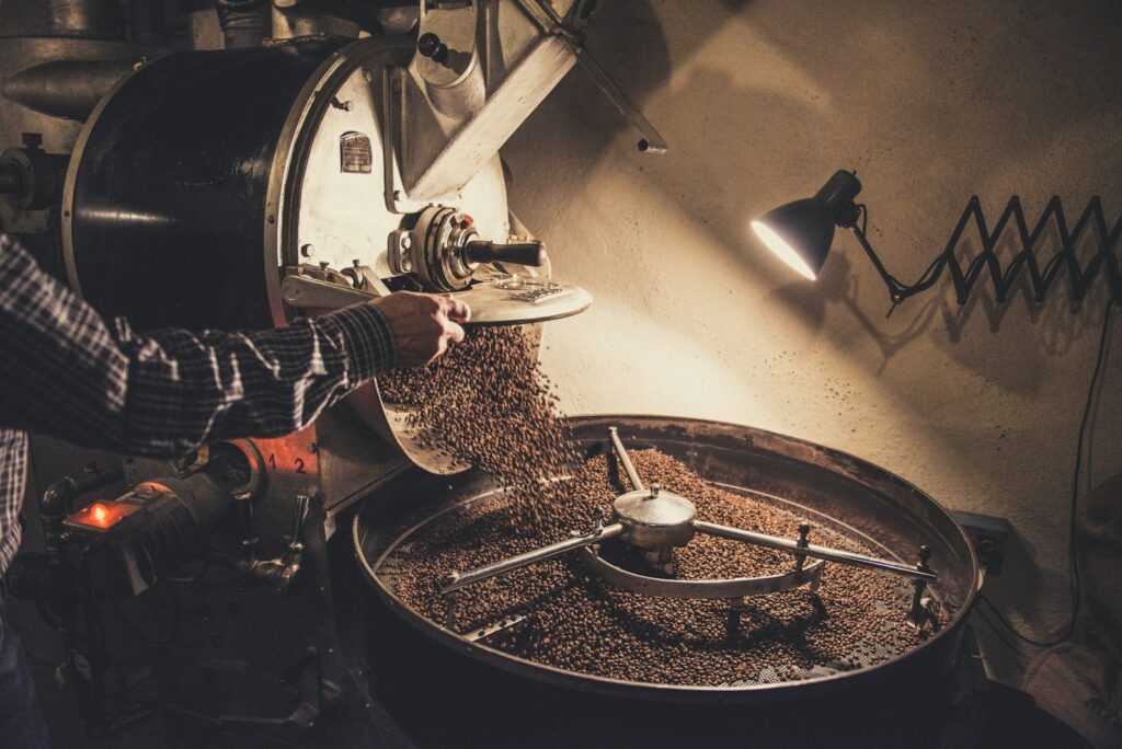 Koffiebonen die in de trechter van een koffiemolen vallen