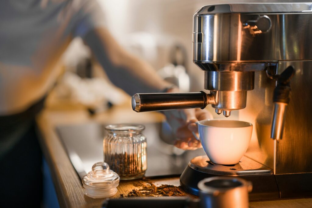 Volautomatische koffiemachine zet een espresso in een glazen kopje
